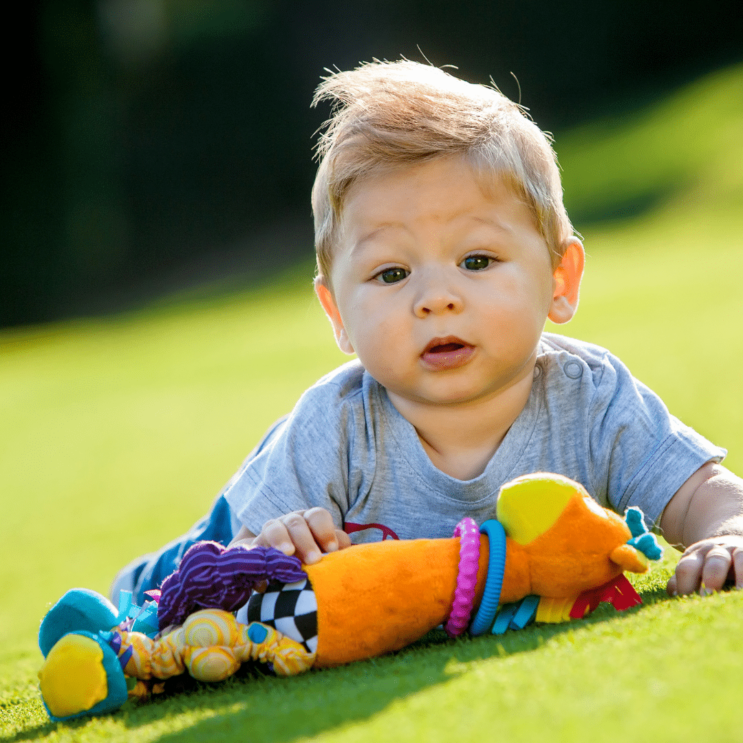 infant playing with a toy outside